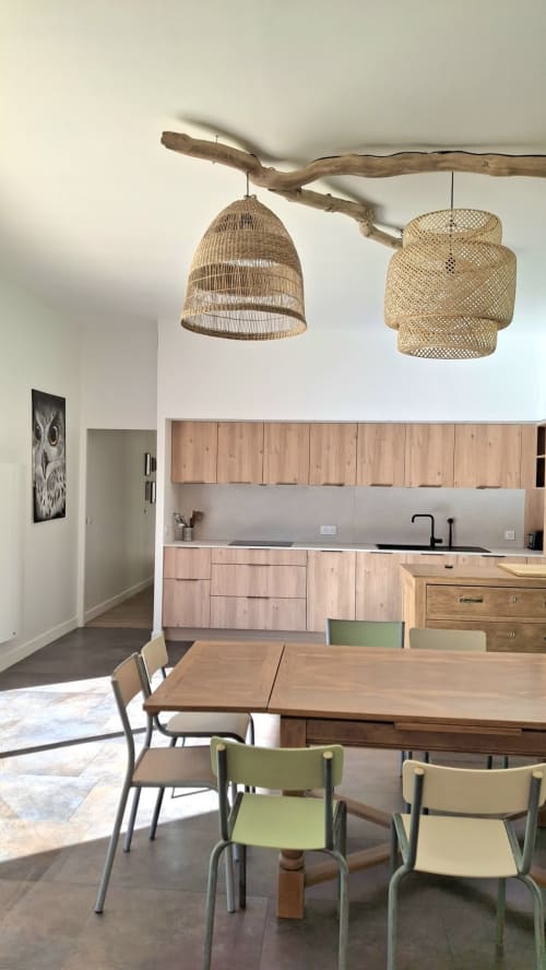 Cuisine et salle à manger modernes de la villa Château De La Malmaison avec luminaires suspendus tressés et mobilier en bois à Aÿ,