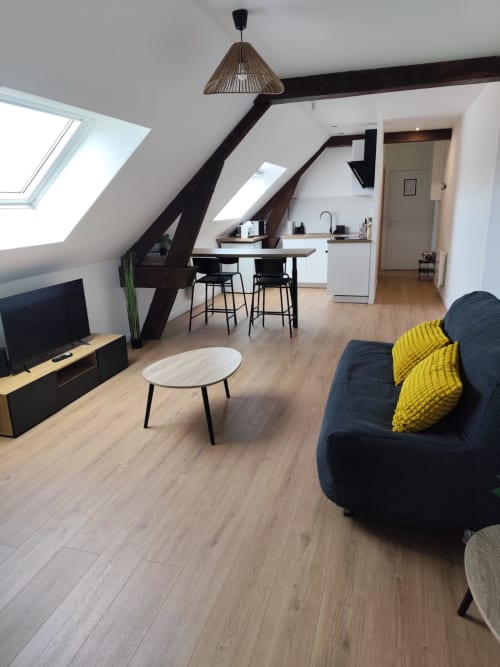 Appartement mansardé moderne à l'hôtel Accolade à Châteaudun avec poutres apparentes, kitchenette, coin repas et séjour