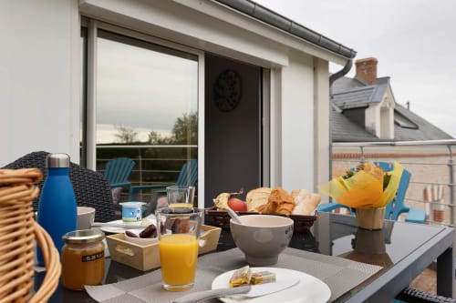 Petit-déjeuner en terrasse au Gîte Le Petit Villeneuve, Saint-Georges-sur-Cher, vue sur jardin et mobilier bleu