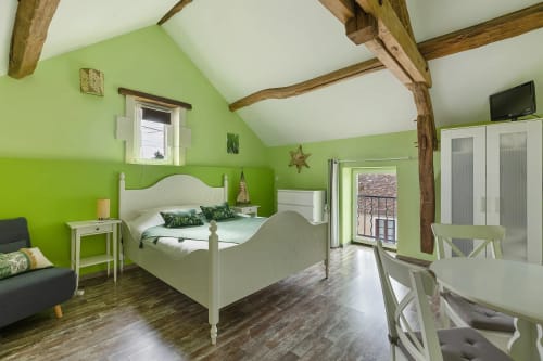 Chambre verte lumineuse avec poutres apparentes, lit blanc au gîte Le Petit Villeneuve Le pressoir