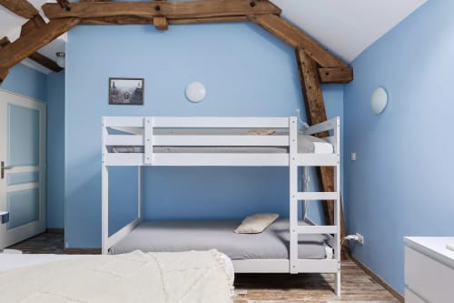 Chambre lumineuse bleu vif avec lits superposés blancs et poutres apparentes à Le Petit Villeneuve, Saint-Georges-sur-Cher