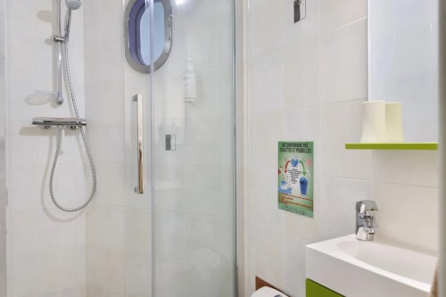 Salle de bain moderne avec douche à l'italienne, lavabo et accents verts au gîte Le Petit Villeneuve à Saint-Georges-sur-Cher