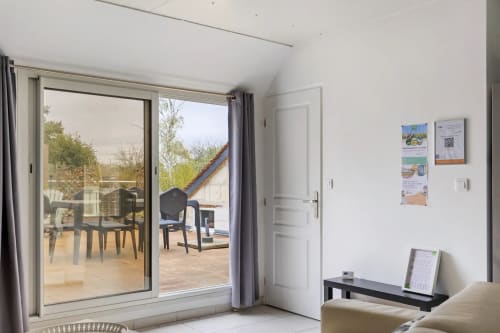 Chambre moderne du gîte au Petit Villeneuve avec portes-fenêtres donnant sur la terrasse du jardin à Saint-Georges-sur-Cher