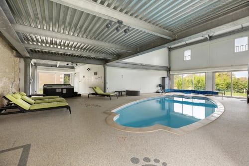 Piscine intérieure du gîte Le Petit Villeneuve à Saint-Georges-sur-Cher avec transats et équipements modernes