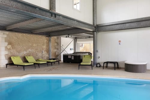 Piscine intérieure avec transats vert citron et plafond industriel au B&B Le Petit Villeneuve, Saint-Georges-sur-Cher