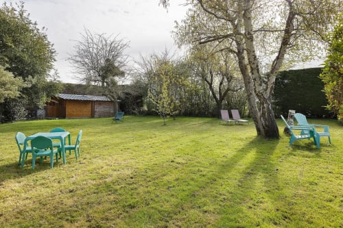 Spacieux jardin du Gîte Le Petit Villeneuve à Saint-Georges-sur-Cher avec des espaces de détente verdoyants et des bouleaux