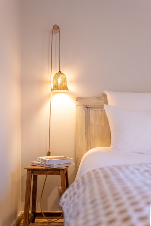 Coin douillet de chambre au Mas Bella Cortis avec lampe suspendue tissée, tabouret bois et livres à La Garde-Adhémar