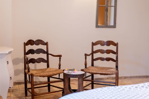 Deux chaises paillées de style rustique face à une petite table à la maison d'hôtes Mas Bella Cortis à La Garde-Adhémar