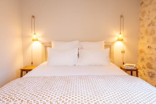 Chambre douillette au Mas Bella Cortis B&B à La Garde-Adhémar avec luminaires suspendus, oreillers blancs et couvre-lit à motifs