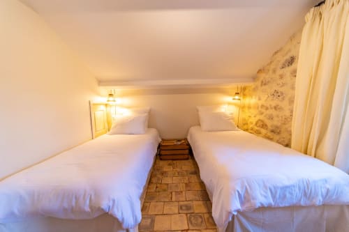 Cozy twin bedroom at Mas Bella Cortis B&B in La Garde-Adhémar with white linens and warm lighting