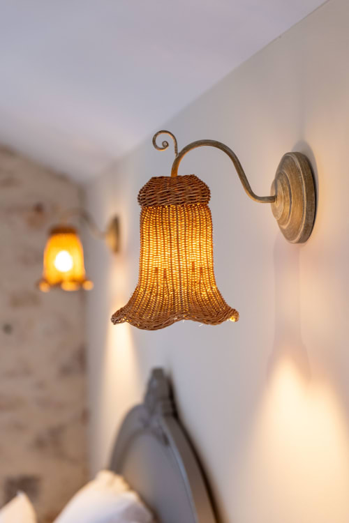 Woven bell-shaped wall sconce at Mas Bella Cortis, La Garde-Adhémar, casting warm ambient light