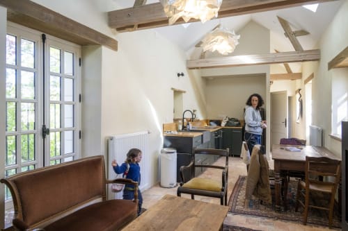 Intérieur de cottage moderne aux poutres apparentes, cuisine et enfant à la Cour Du Liège, Baugé-en-Anjou