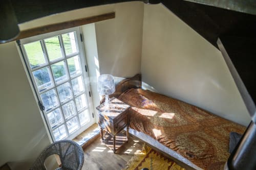 Chambre lumineuse au gîte Le Colombier, Cour Du Liège, avec vue sur le jardin par grandes fenêtres et lit rustique en bois