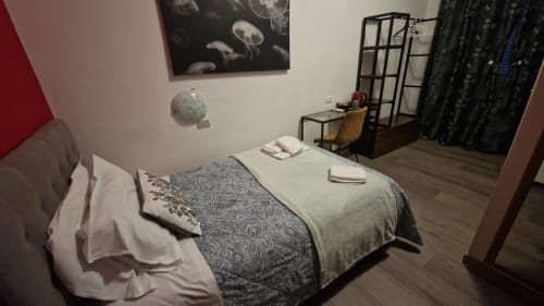 Cozy single room at Hotel Genzianella in Florence with bed, desk, chair, and dark curtains