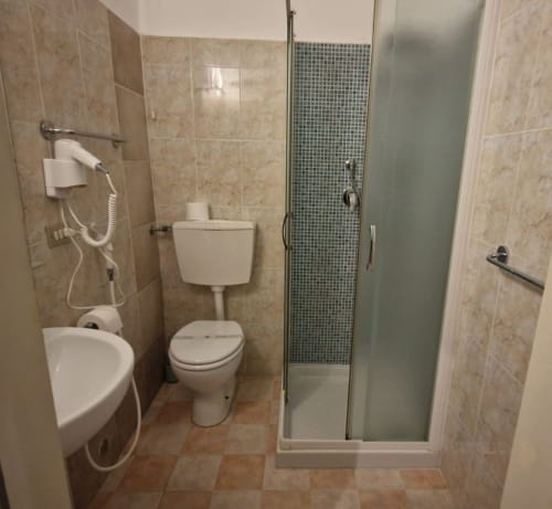 Hotel Genzianella bathroom in Florence with toilet, bidet, shower enclosure and cream tile walls