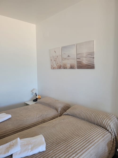 Luminosa habitación con dos camas a rayas, decoración temática marina y vistas al mar en Apartamentos A la Orilla del Mar, Matalascañas