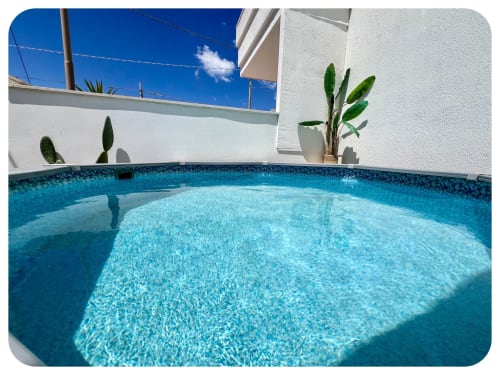 Piscina privata blu cristallo di Villa Adua a Ostuni con muri bianchi e piante verdi