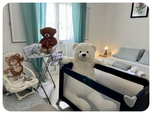 Dimore Adua villa in Ostuni: nursery room with white teddy bear in crib, brown bears, baby chair, turquoise curtains and