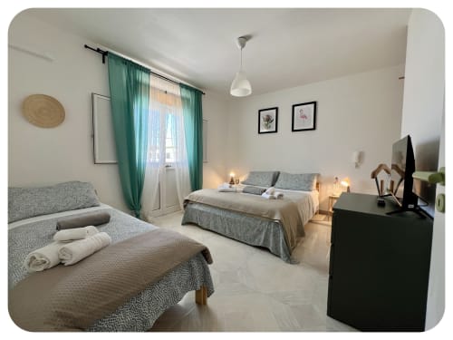 Spacious bedroom at Villa Adua in Ostuni with two beds, green curtains, pendant lighting, and garden view
