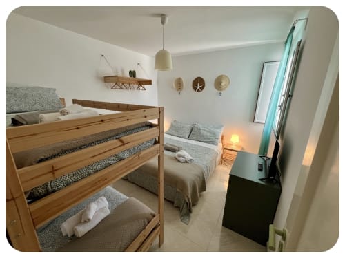 Bright villa bedroom at Dimore Adua, Ostuni with wooden bunk beds, single bed, pendant light, wall decor, and garden view