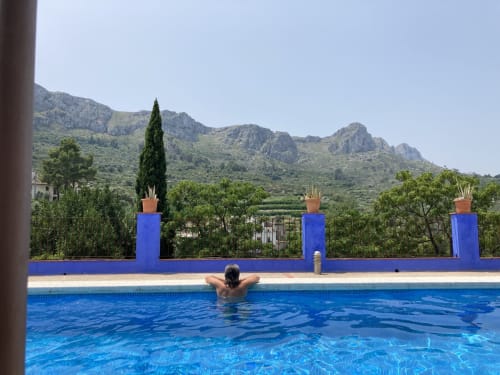 Guest relaxing in pool at Casa Gallinera vacation home in Alicante, Spain, with mountain views