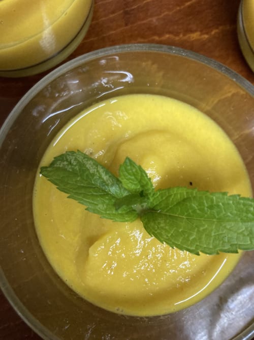 Creamy yellow soup with fresh mint garnish served at Casa Gallinera in Alicante