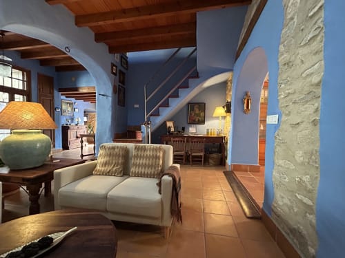 Casa Gallinera boutique vacation home living room in Alicante with blue walls, cream sofa, wooden beams and rustic decor