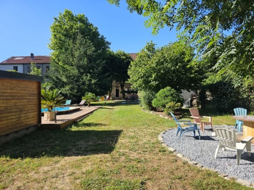 Cour jardin de la Bastide du Thoré avec pelouse, espaces détente et arbres ombragés à Labastide-Rouairoux