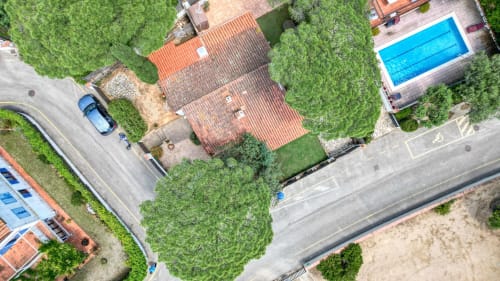 Vue aérienne de la propriété Finques Garcia Enrich à Palafrugell avec toits en terre cuite, piscine, jardins luxuriants et parking