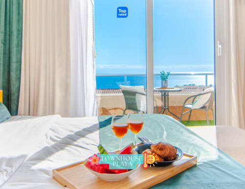 Lujosa habitación en casa adosada de Adeje con vistas al mar, bandeja de desayuno y terraza balconada al océano visible desde las ventanas