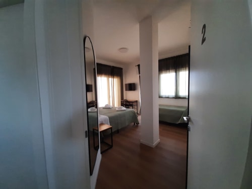 Camera moderna al B&B Bari Centro con letti, specchi, parquet e luce naturale dalle finestre