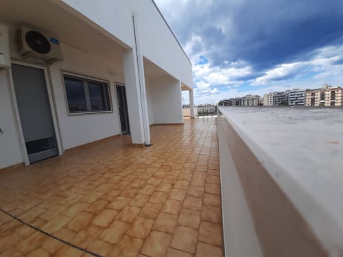 Ampia terrazza panoramica del B&B Bari Centro con mattonelle in cotto, struttura bianca e vista sulla città di Bari
