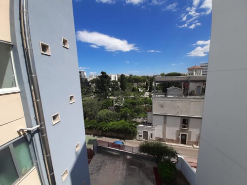 Vista di Bari dalla terrazza della camera d'hotel con parco verde e edifici storici