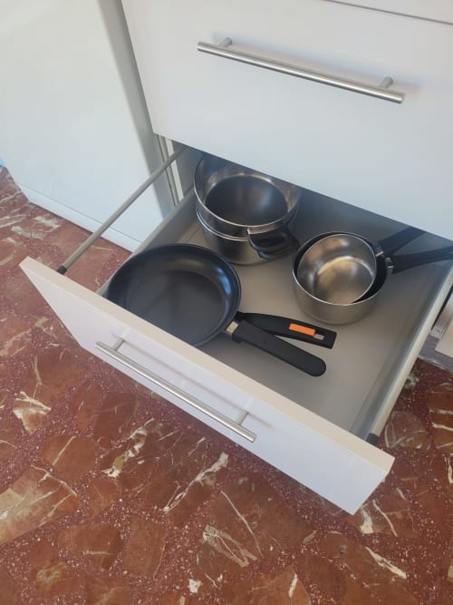 Cajón de cocina abierto en el Apartamento 8 de Apartamentos A la Orilla del Mar, Matalascañas, con menaje y utensilios de cocina