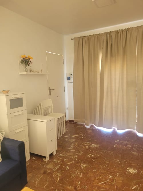 Zona de cocina de estudio con electrodomésticos blancos, mesa de comedor y cortinas beige con vistas al mar en Matalascañas