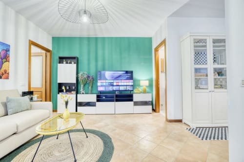 Lussuoso appartamento B&B moderno a Pisa con parete azzurra, arredi bianchi, TV e vista sul giardino