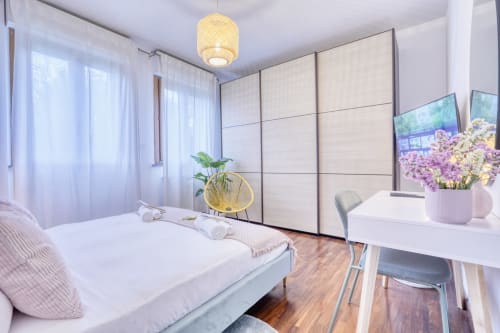 Camera moderna presso SleepWithMe Luxury B&B a Pisa con letto matrimoniale, scrivania, armadio e vista sul giardino