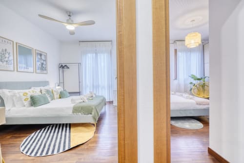 Camera moderna di SleepWithMe Luxury B&B a Pisa con divisorio in legno, dettagli verdi e vista sul giardino dalle porte vetrate