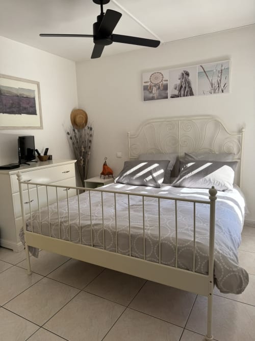 Chambre Bohème à L'instant D'un Séjour au Gua, France avec lit en métal et ventilateur de plafond