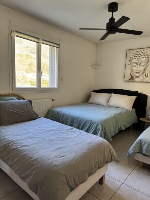 Chambre Bodhi à L'instant D'un Séjour B&B au Gua : deux lits, ventilateur de plafond, vue montagne