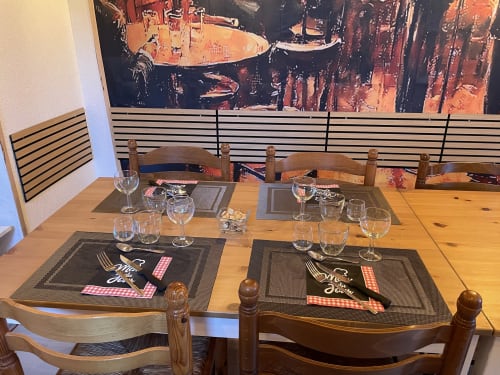 Salle à manger de la maison d'hôtes Le Petit Moulin à Pouzauges avec couverts et verres à vin