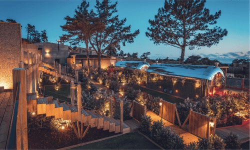 Charm Nature BnB ao anoitecer, Azóia Portugal - Trailer Airstream vintage iluminado e construções rústicas de madeira entre a natureza