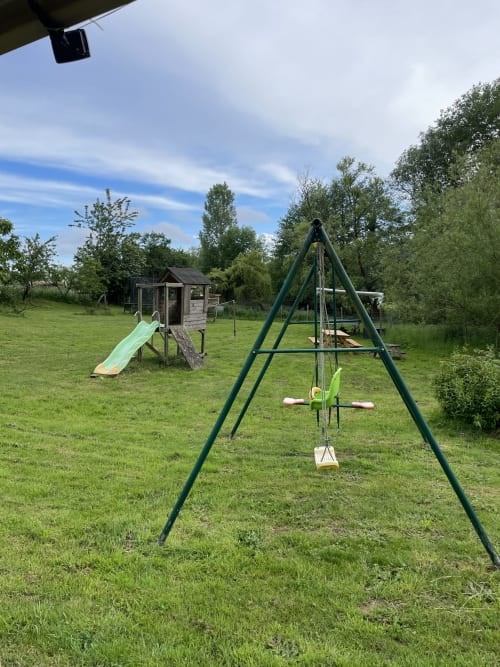 Aire de jeux pour enfants avec balançoires et toboggan à la maison d'hôtes Le Petit Moulin à Pouzauges