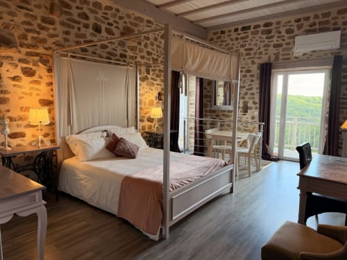 Lit à baldaquin romantique dans chambre en pierre aux Instants Volés, Tudeils avec vue jardin et accès spa privé