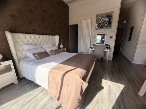 Luxueuse chambre double aux Instants Volés avec tête de lit capitonnée crème, mur d'accent sombre et équipements modernes