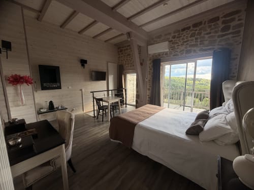 Spacieuse chambre double aux Instants Volés avec lit, balcon surplombant les jardins, TV et équipements modernes à Tudeils