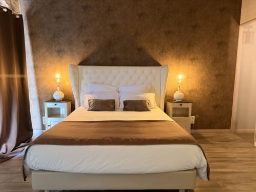 Luxueuse chambre double aux Instants Volés avec tête de lit capitonnée crème, éclairage ambiant et mur d'accent texturé