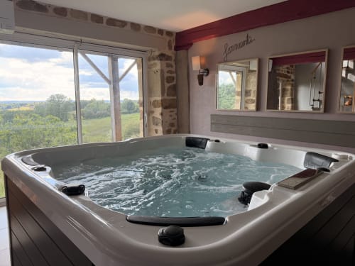 Jacuzzi luxueux avec vue sur la campagne à l'hôtel-boutique Les Instants Volés à Tudeils, France