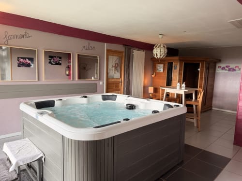 Luxueux jacuzzi XXL aux eaux bleues dans l'espace spa de l'hôtel boutique Les Instants Volés à Tudeils, France