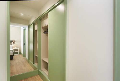 Modern walk-in closet with mirrored sliding doors and shelving at Sintra Green Chalet Bed & Breakfast, Portugal